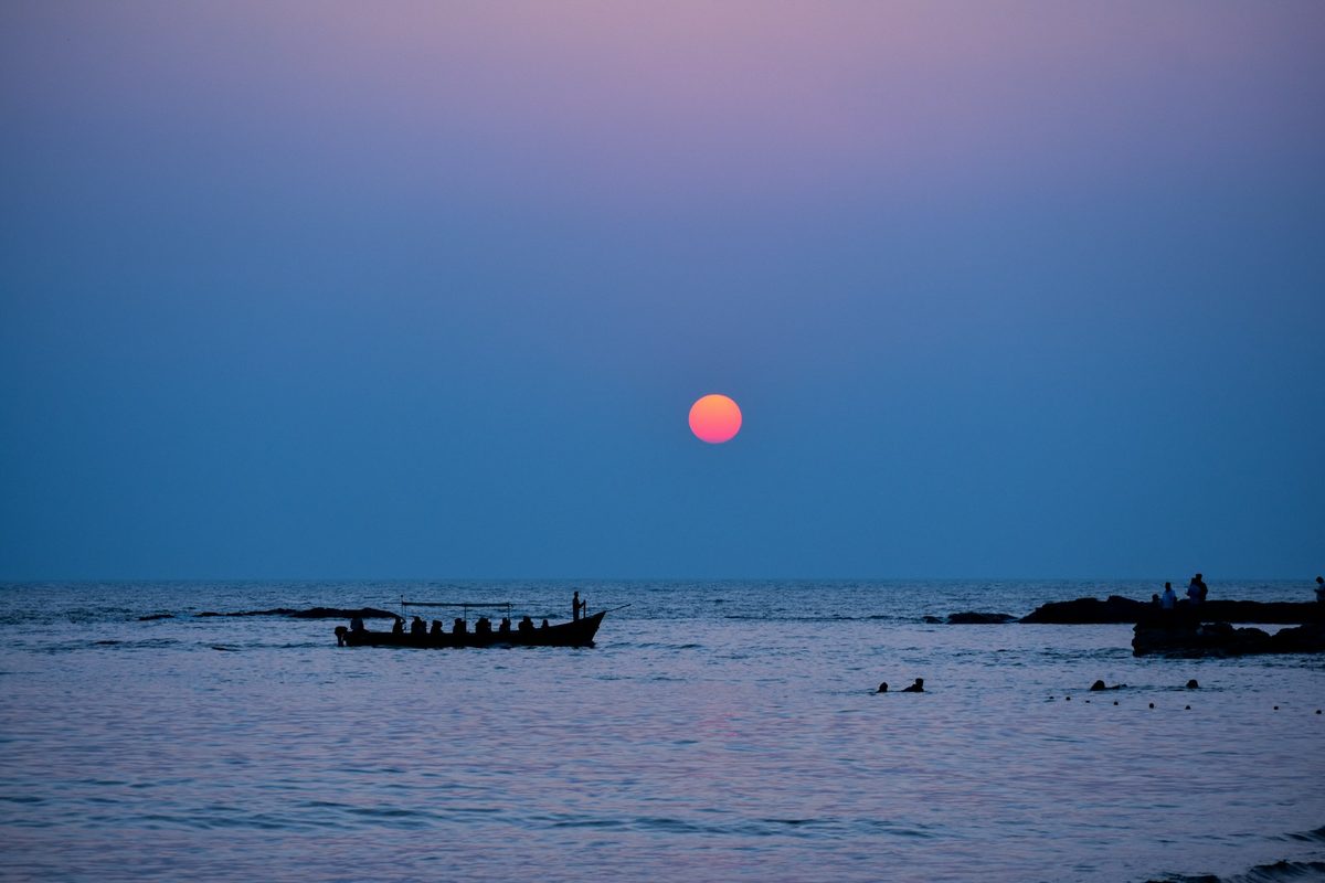 Boat sailing at sunset off Gokarna