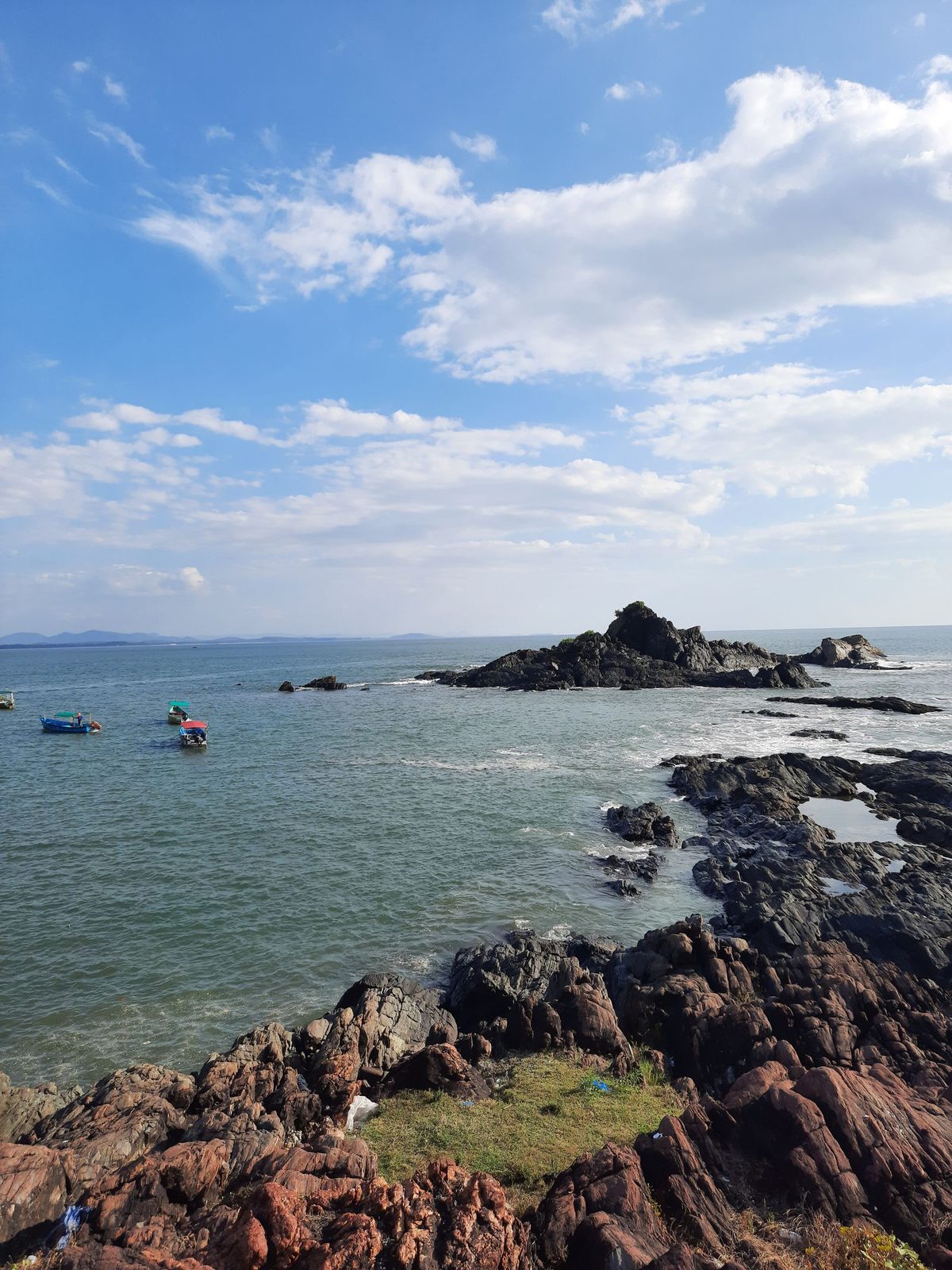 Rocky coastline of Gokarna under a blue sky